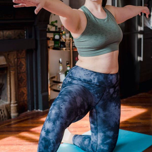 Smiling woman in a light-filled room after a yoga session.