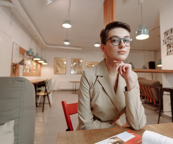 Woman sitting at a desk with a straight back, looking calm.